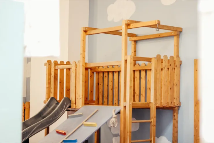 Klettergerüst aus Holz mit Rutsche im Spielbereich