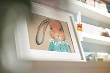 Das Anna Shop: Gerahmte Zeichnung eines Hasen mit langen Ohren, der ein altmodisches, blaues Kleid trägt.