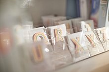 Das Anna Shop: Verpackte Buchstaben in bunten Farben als Aufnäher.